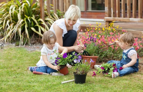 Operatives wearing PPE while using garden machinery