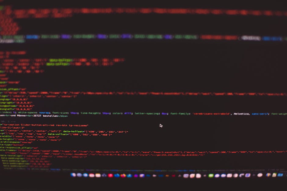 A close-up view of a computer monitor displaying lines of colorful code on a dark background, with a brightly glowing blue light source illuminating part of the screen. The monitor is situated on a cl